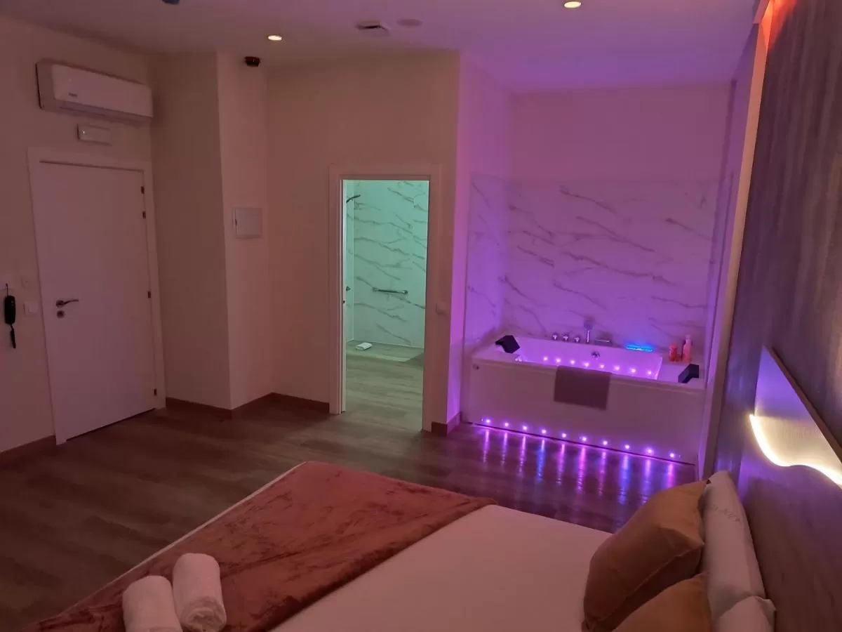 Habitación con bañera de hidromasaje y luces Paradise Suites Madrid