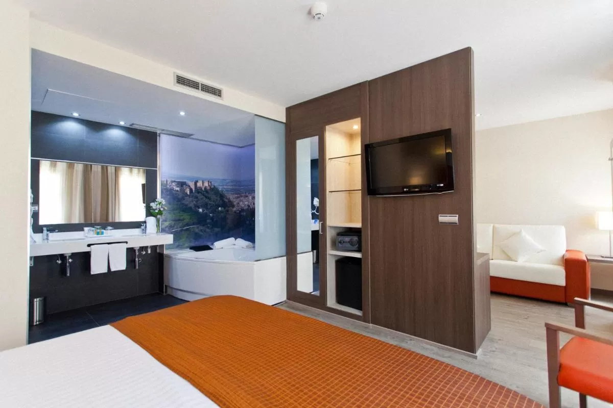 Habitación con jacuzzi al lado de la cama en Porcel Sabica Granada